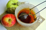 Чай из листьев яблони в прозрачной чашке, рядом лежат яблоки