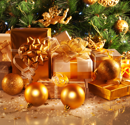 Photo of luxury gift boxes under Christmas tree, New Year home decorations, golden wrapping of Santa presents, festive fir tree decorated with garland, baubles and angels, traditional celebration