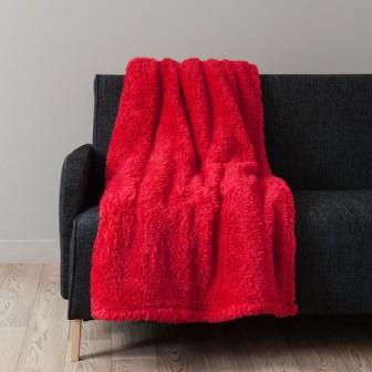 Красный меховой плед на черном диване