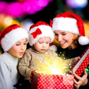 Мама и двое детей в новогодних костюмах распаковывают подарки