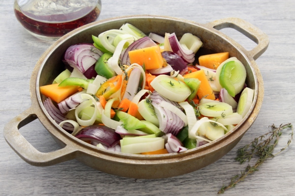 Порубленные овощи - тыква, морковь, сельдерей, лук - на сковороде с высокими бортами