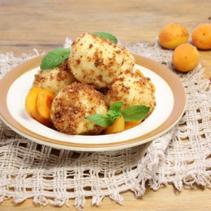 Творожные кнедлики с абрикосовой начинкой на тарелке